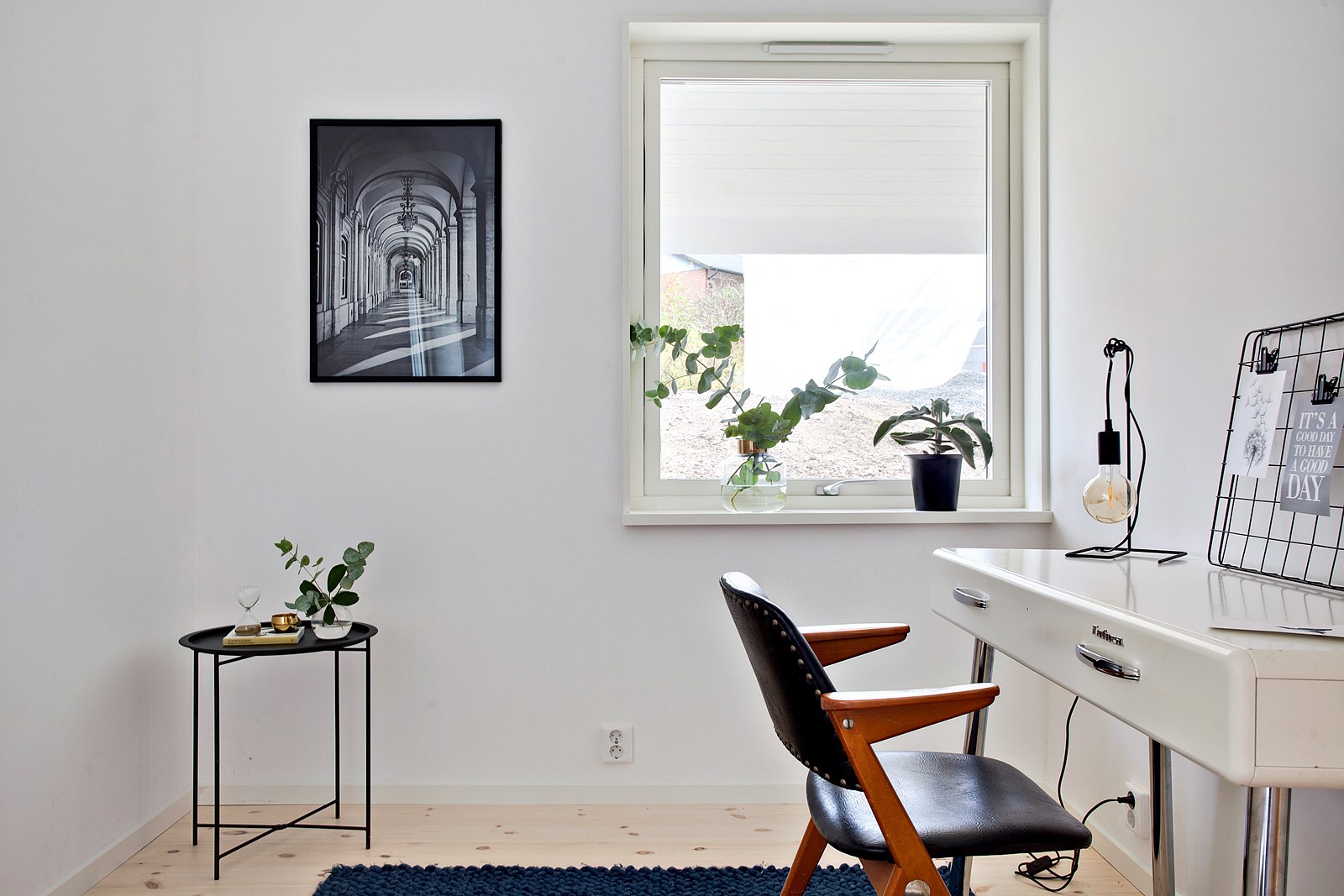 Inspiration för att inreda kontor. Kontor med vita väggar och svart stol, tavla på väggen och vitt skrivbord.